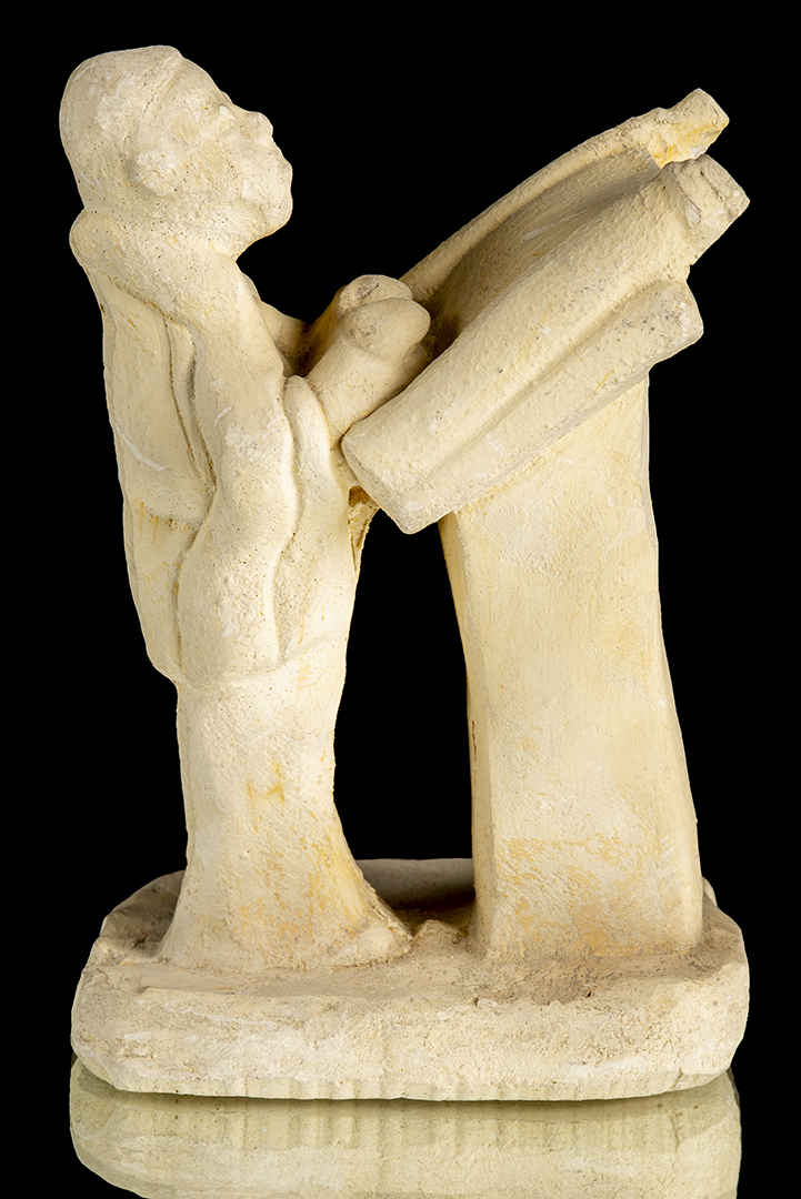 Escultura de yeso de una persona leyendo